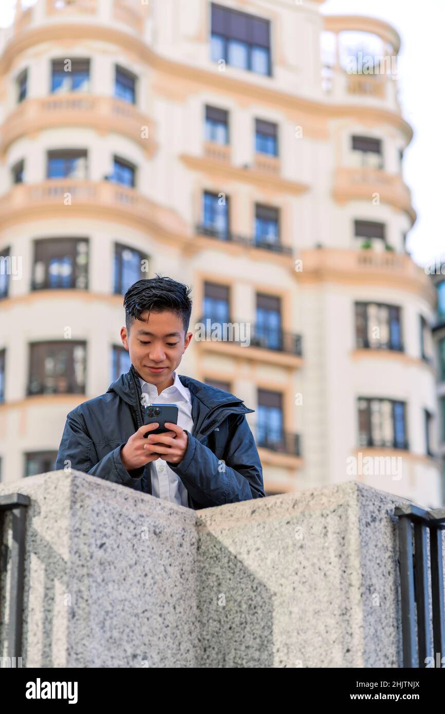 asian man sending a message from his smartphone Stock Photo