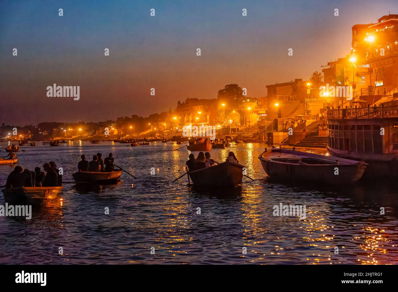 Rowing boats take tourists to the nightly aarti ceremony on the ghats on the River Ganges at Varanasi, a city in Uttar Pradesh, north India Stock Photo