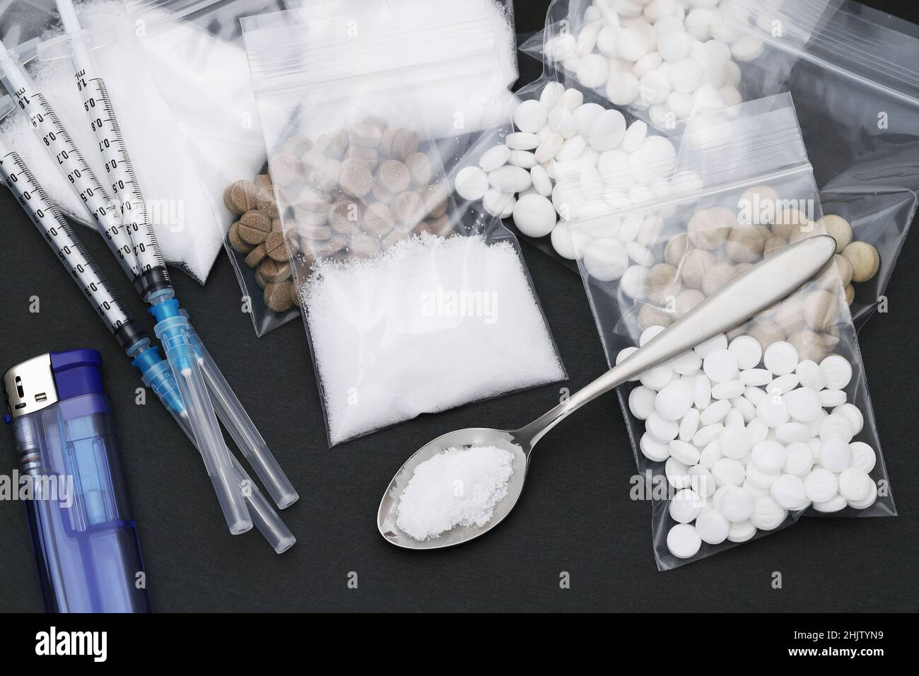 Cooked heroin drugs and injection syringe on black background Stock Photo