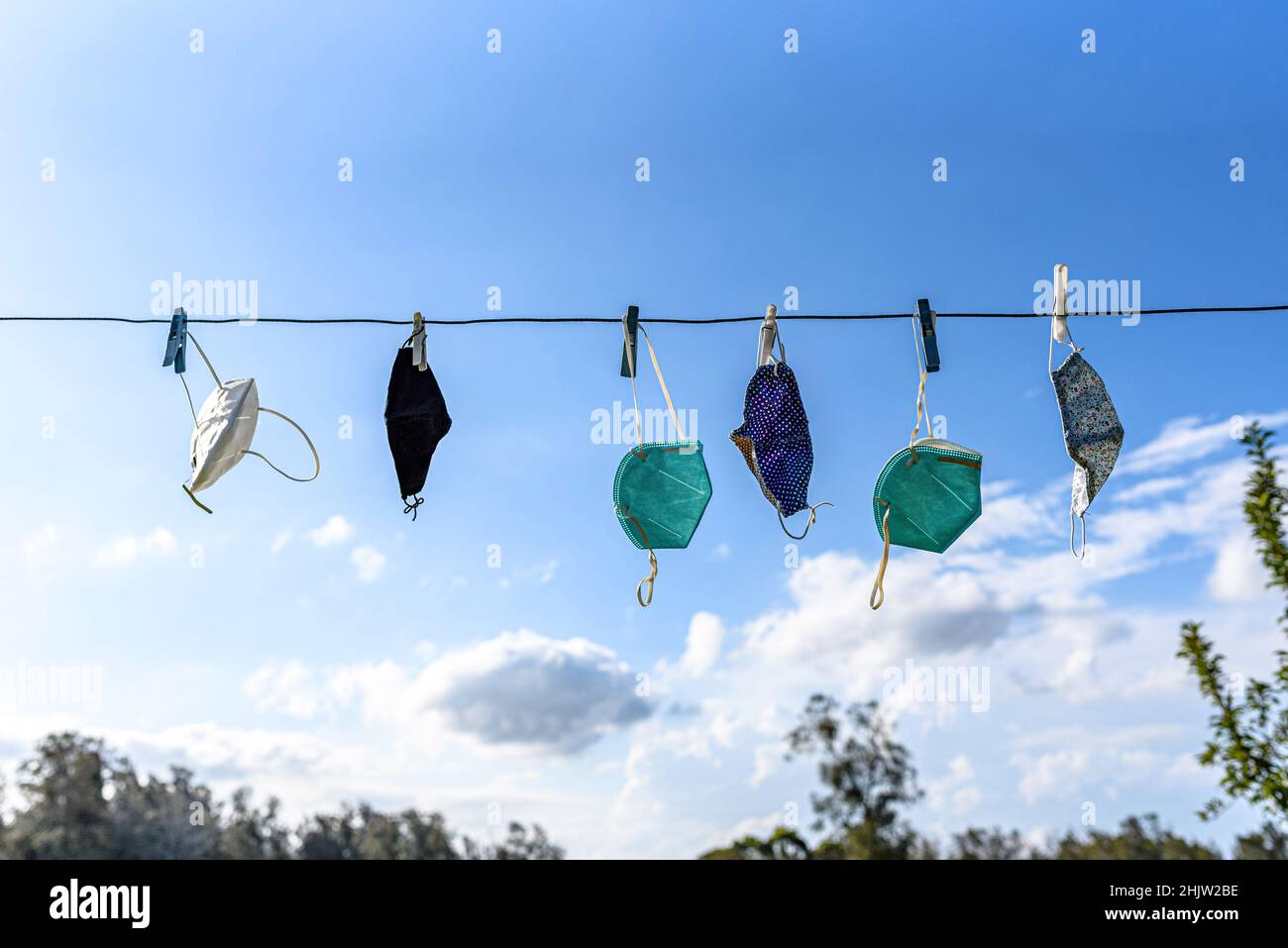 A mix of masks hanging on a clothesline during the 2022 summer in Australia following the arrival of the omicron covid variant Stock Photo