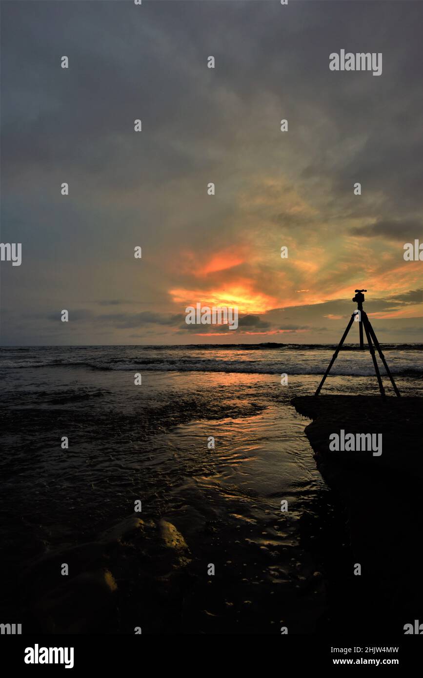 Silhouette shot of tripod with camera on a rock during sunset Stock ...
