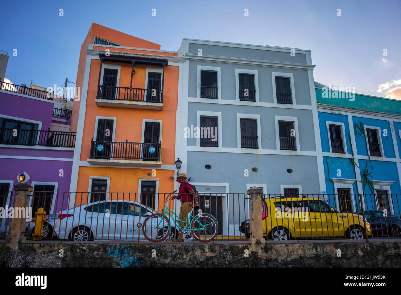 A cyclist passes the colorful facades of historic buildings in Old San Juan, Puerto Rico Stock Photo