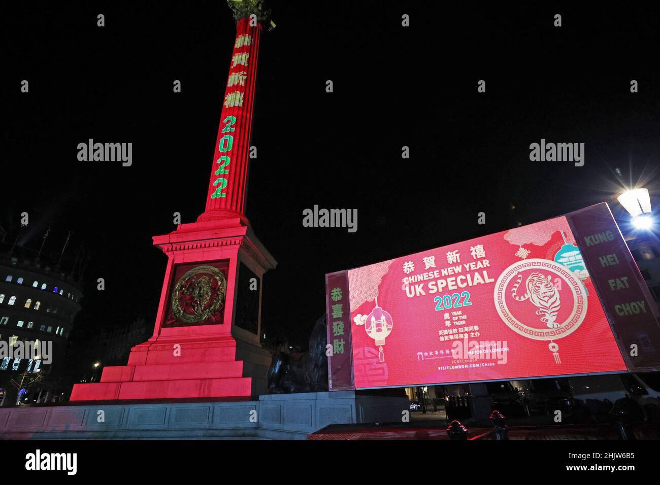 London, UK. 31st Jan, 2022. Photo taken on Jan. 31, 2022 shows the Nelson's Column and a screen nearby illuminated in red to celebrate the Chinese Lunar New Year at Trafalgar Square in London, Britain. Credit: Li Ying/Xinhua/Alamy Live News Stock Photo