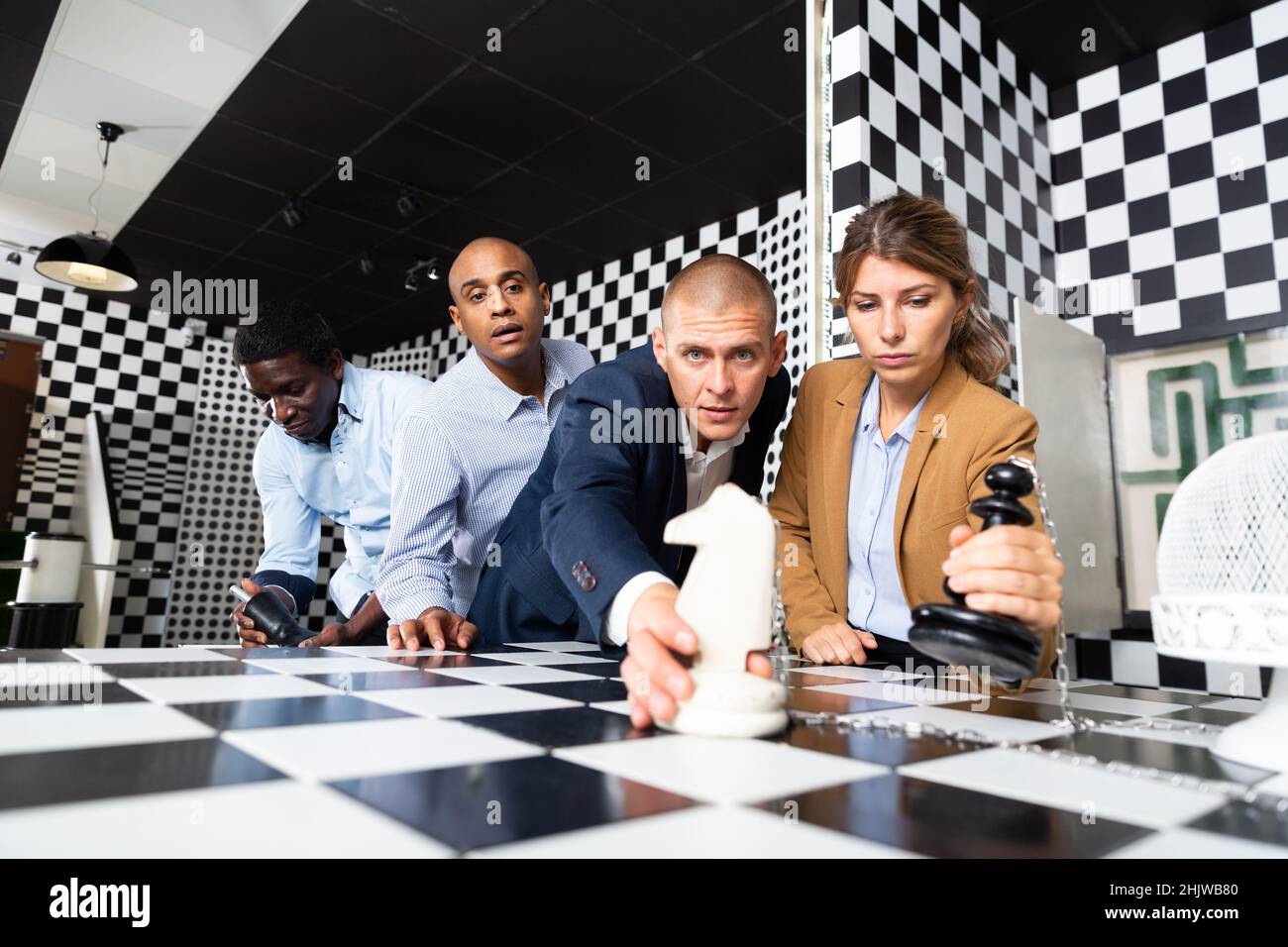 Businesspeople discussing near chessboard in quest room Stock Photo