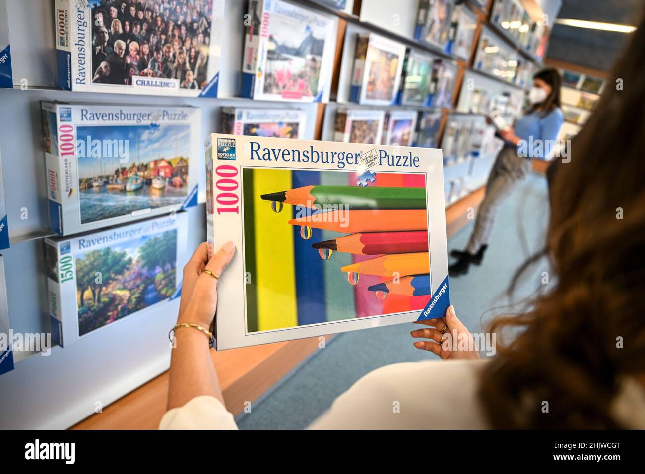 Ravensburg, Germany. 31st Jan, 2022. A female employee holds a puzzle