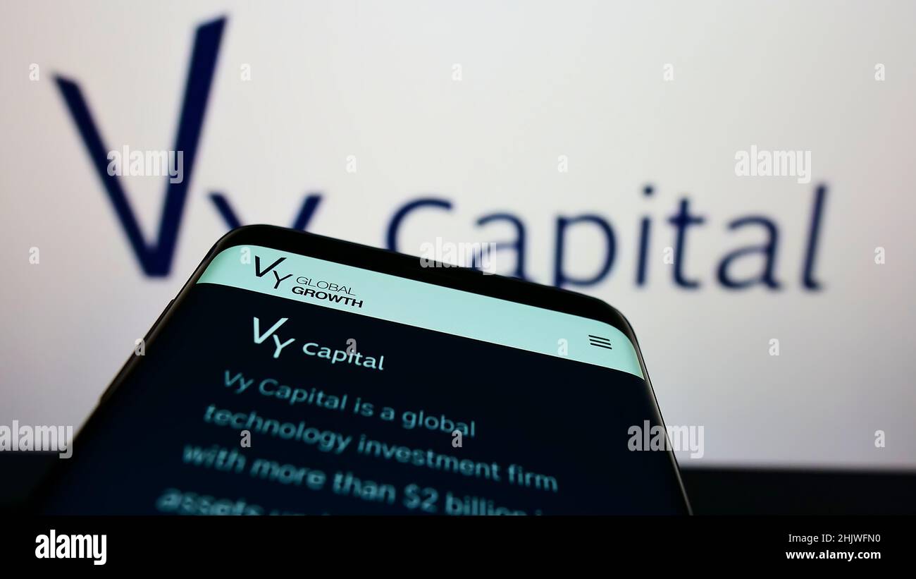 Mobile phone with webpage of investment company Vy Capital on screen in front of business logo. Focus on top-left of phone display. Stock Photo