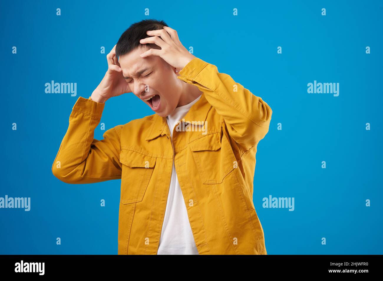 Emotional young man touching his head and shouting in despair Stock ...