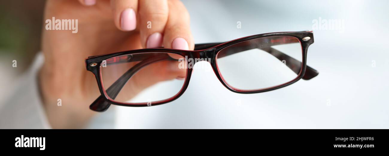 In female hand there are stylish fashionable glasses in black frames Stock Photo