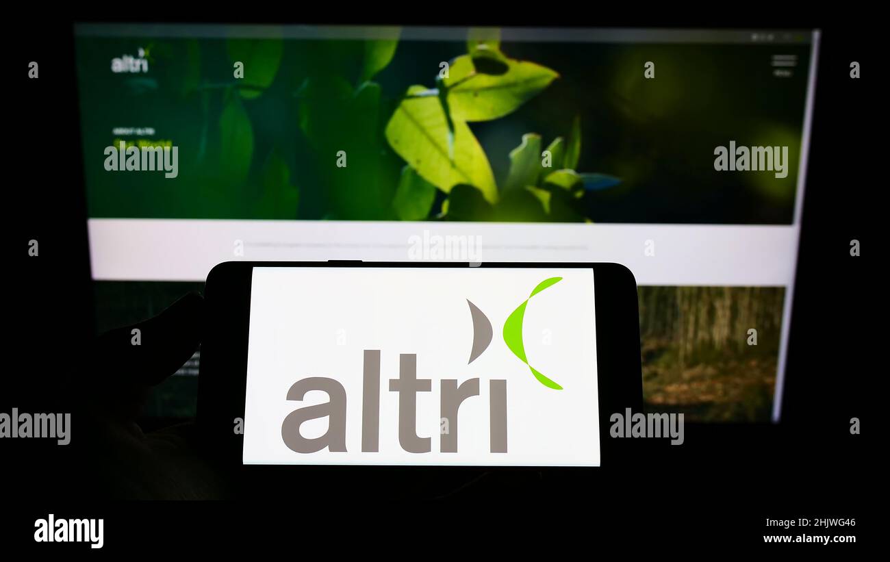 Person holding cellphone with logo of Portuguese conglomerate Altri SGPS SA on screen in front of business webpage. Focus on phone display. Stock Photo