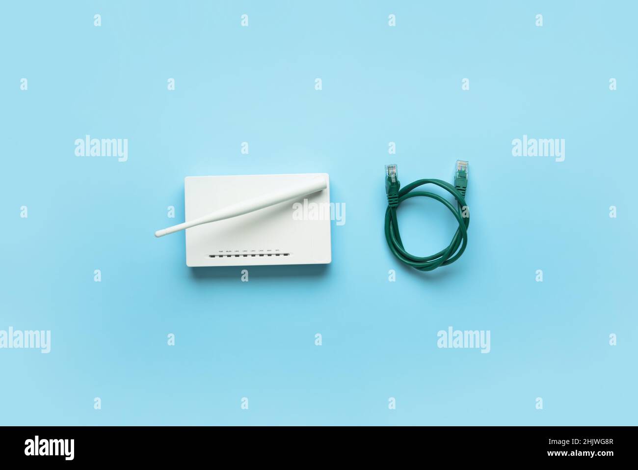 Wi-Fi router with antenna and network cable on color background Stock