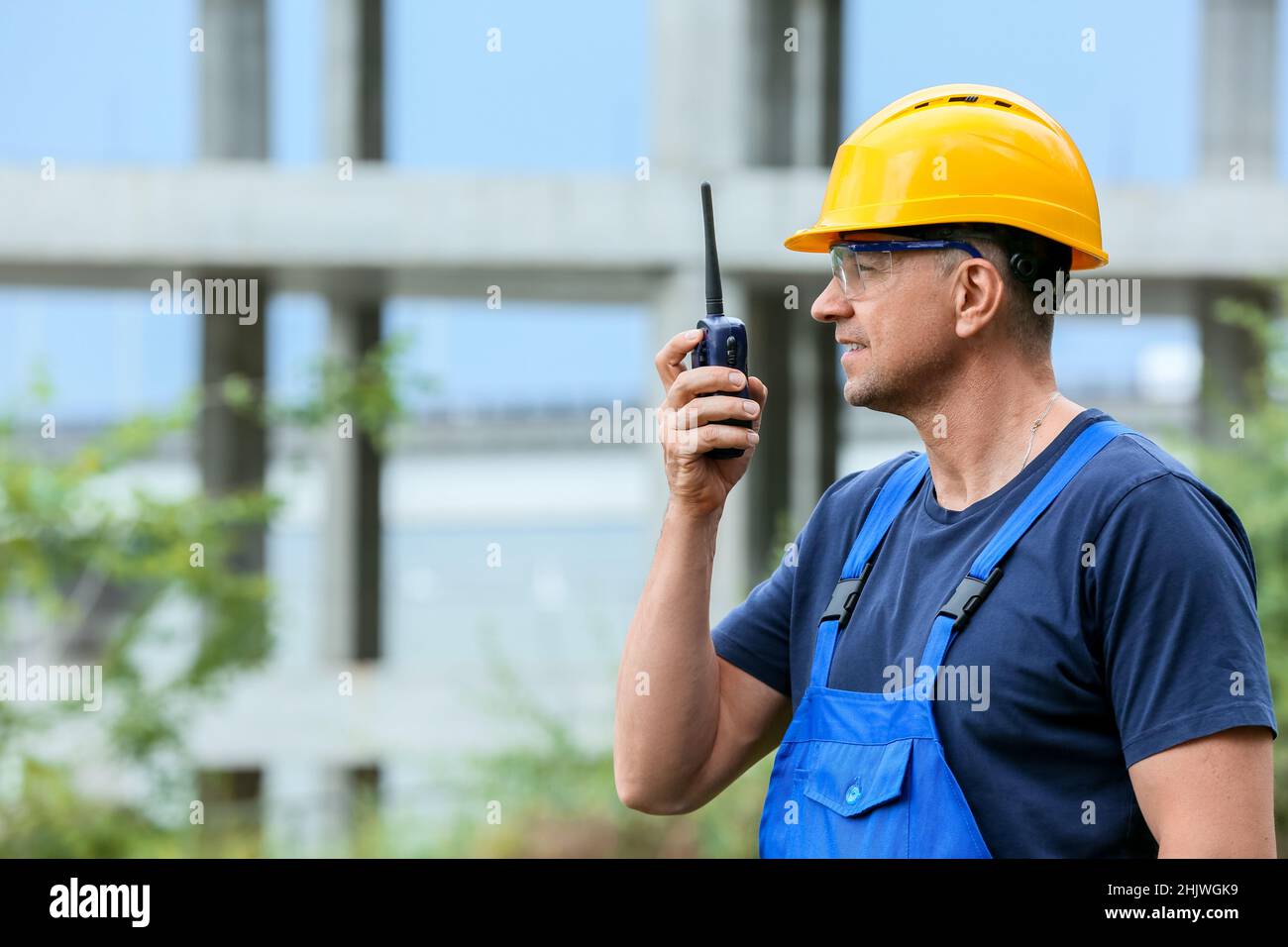 Male worker with safety equipment and radio transmitter at construction ...