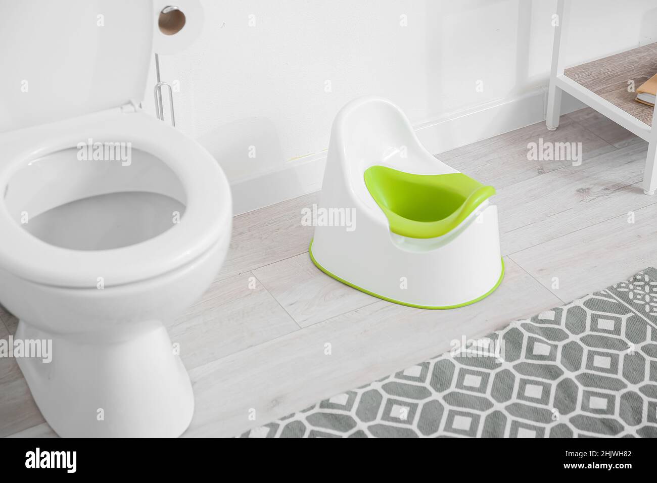 Toilet bowl and potty near white wall Stock Photo Alamy