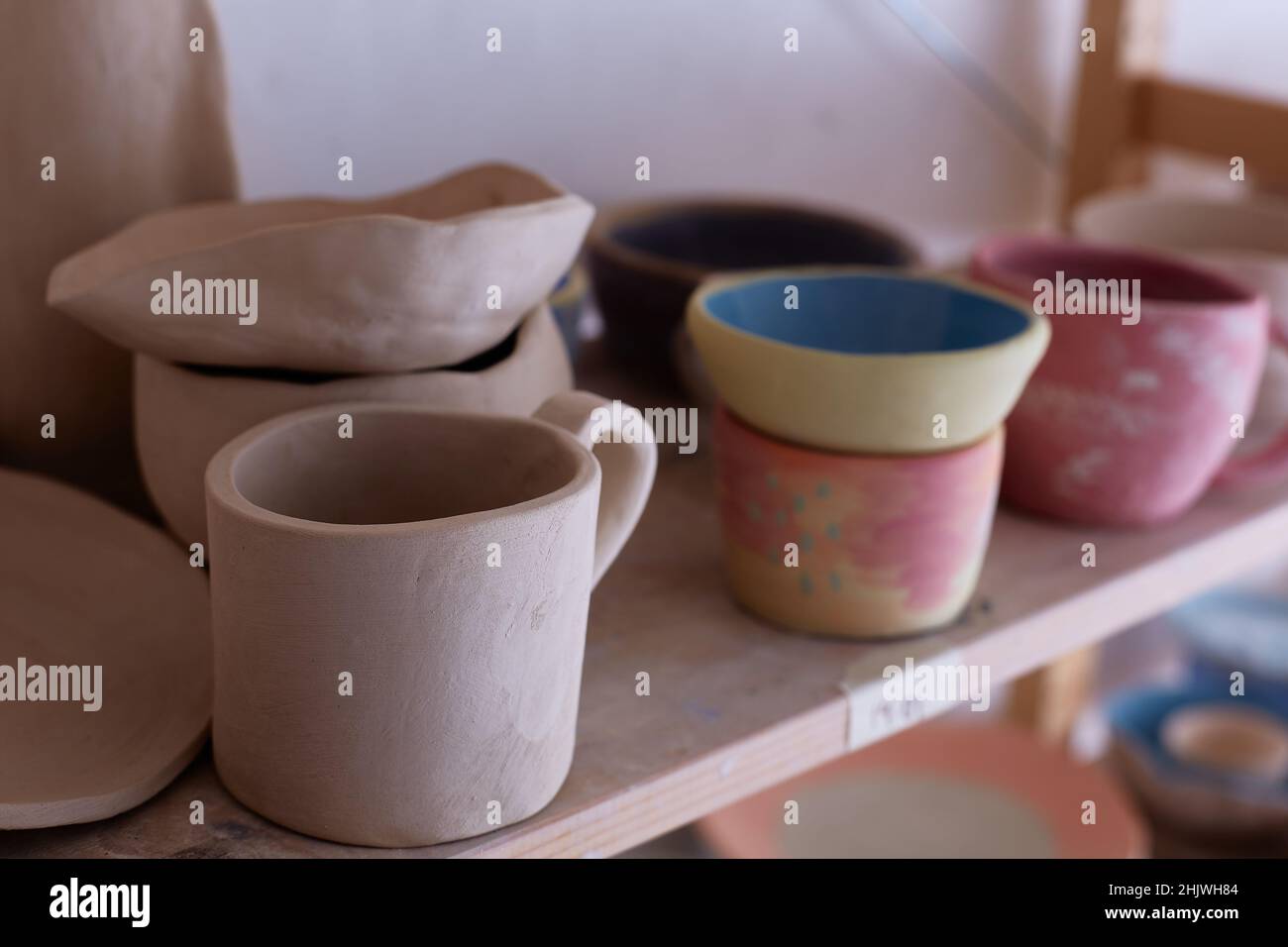 Empty handmade tableware. ceramic cups on the shelf. Handmade work. Stock Photo