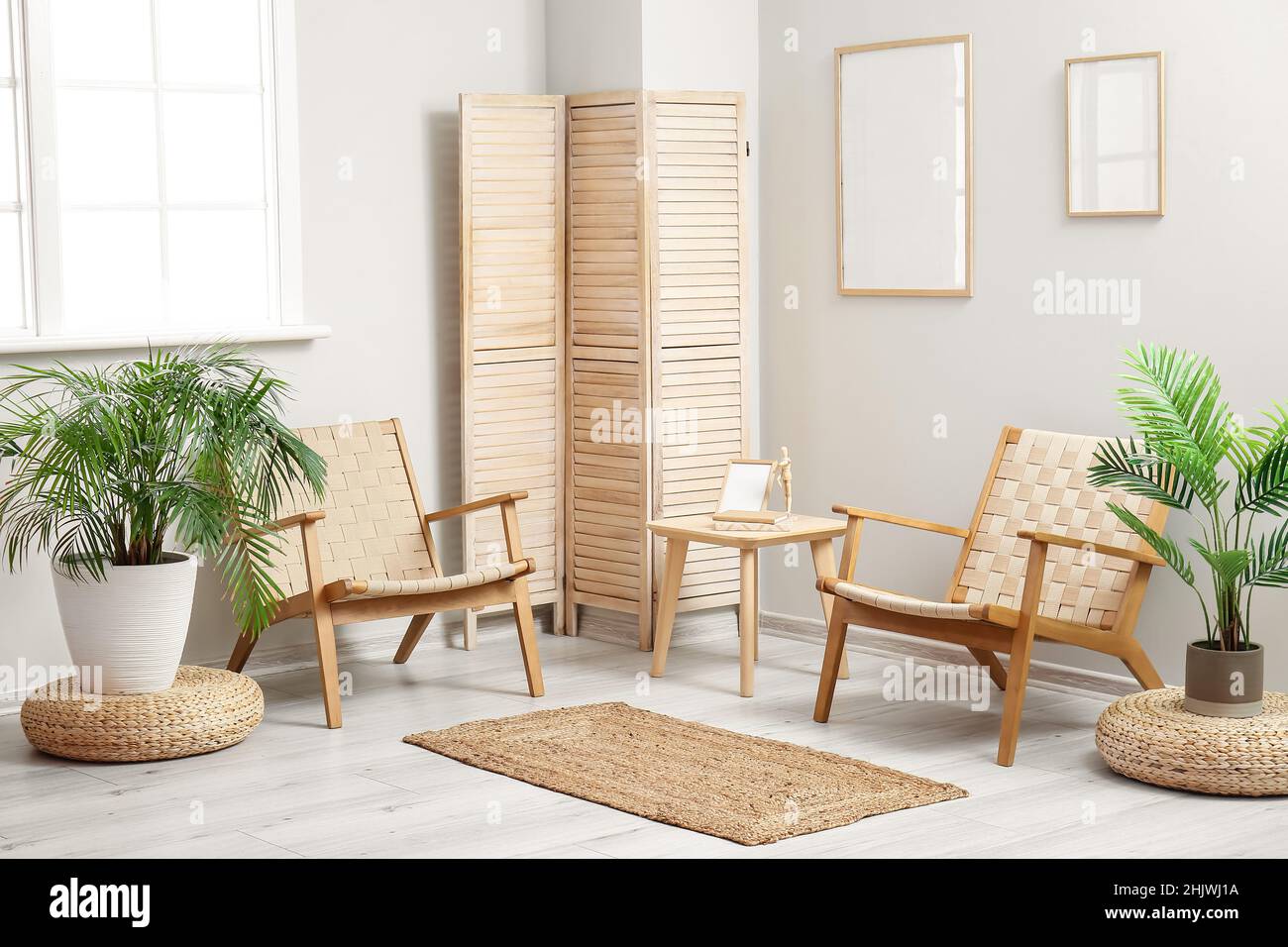 Stylish interior of living room with armchairs, houseplants and wicker ...