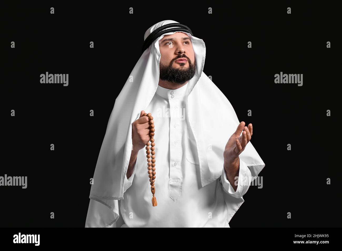 Muslim man praying on black background Stock Photo