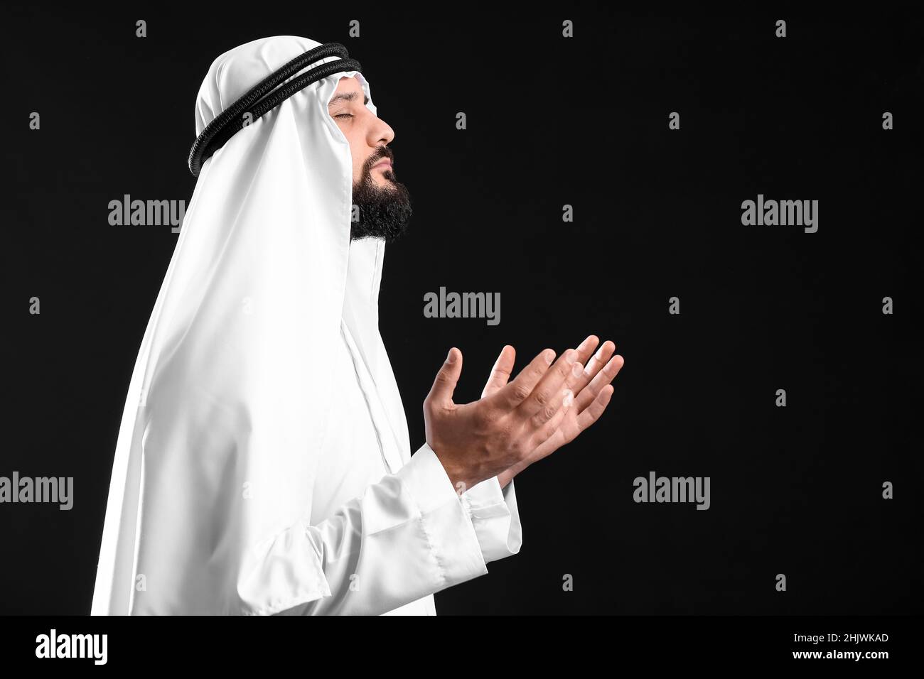 Muslim man praying on black background Stock Photo