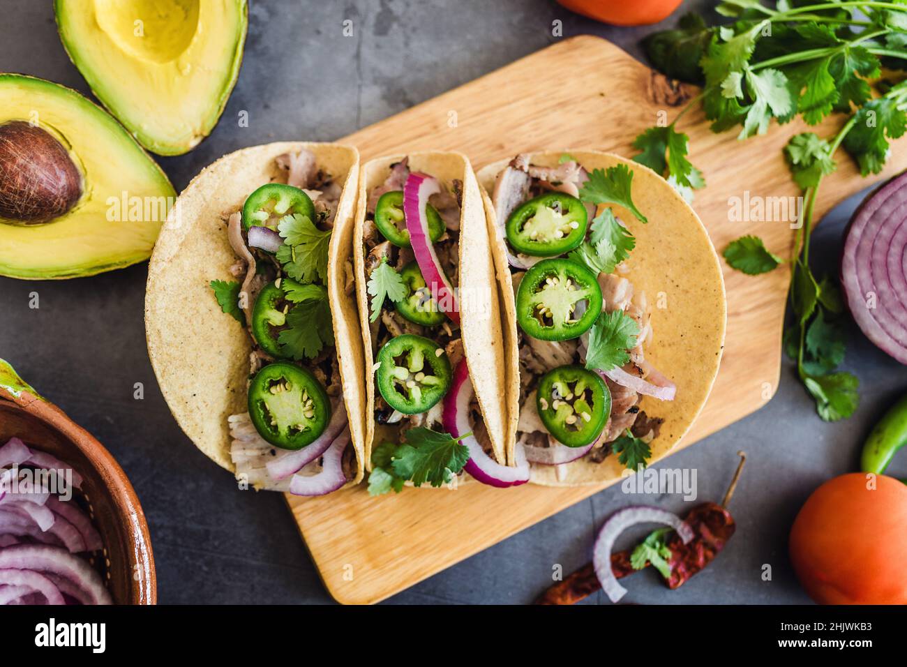 mexican street tacos ingredients with pork carnitas, tortillas, avocado