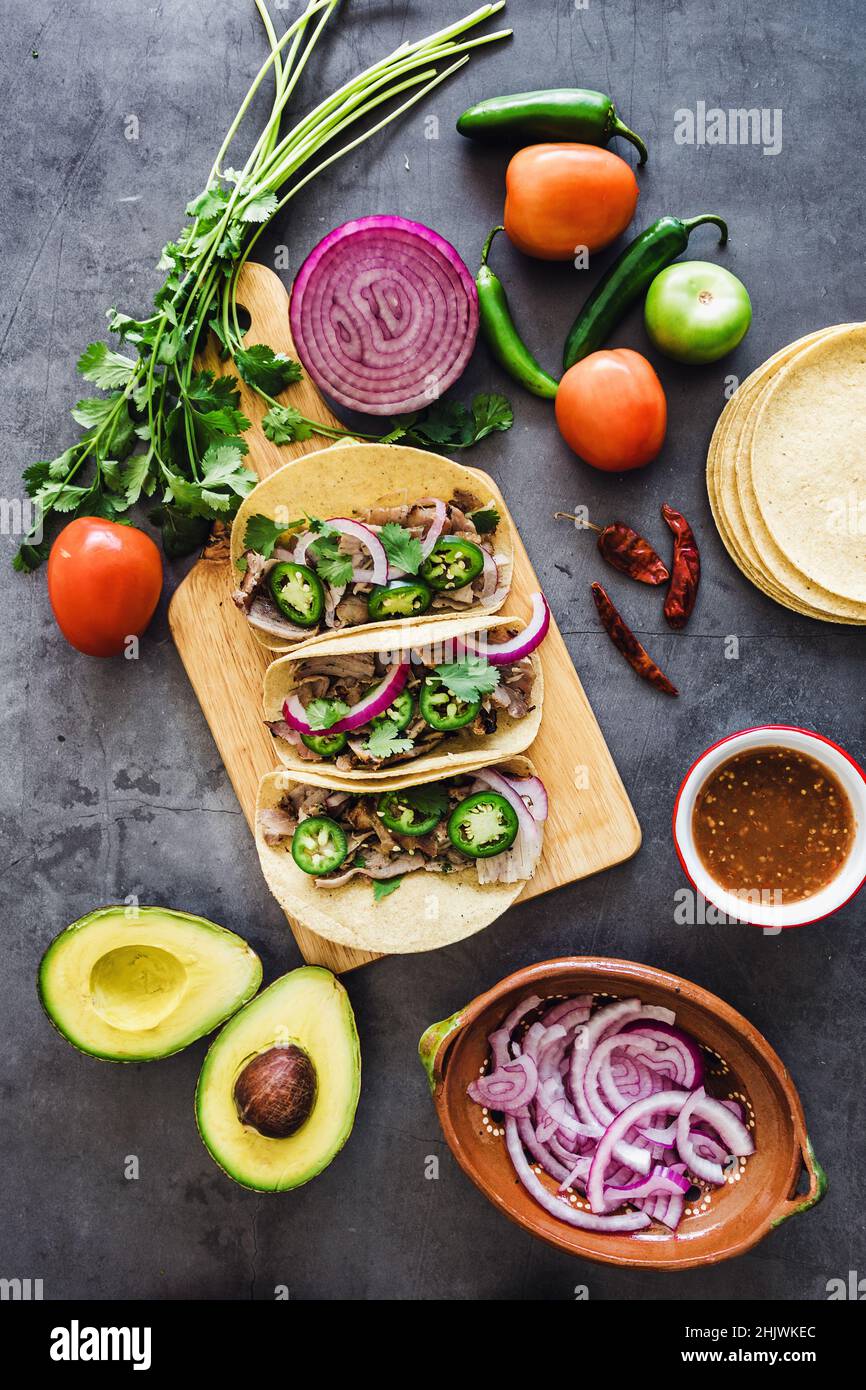 mexican street tacos ingredients with pork carnitas, tortillas, avocado