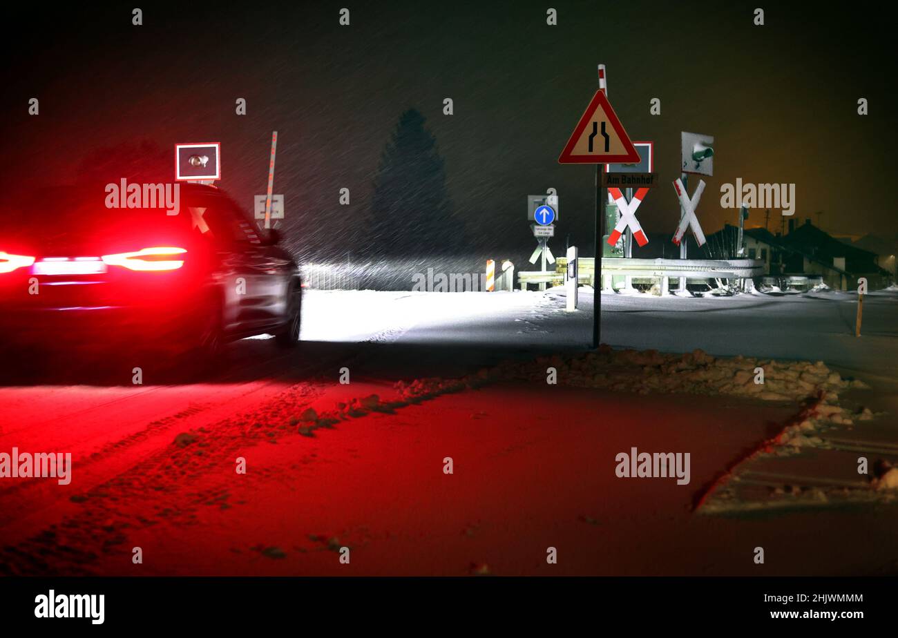 Apfeltrang, Germany. 01st Feb, 2022. A car drives over a railroad crossing in the early morning snow. Credit: Karl-Josef Hildenbrand/dpa/Alamy Live News Stock Photo