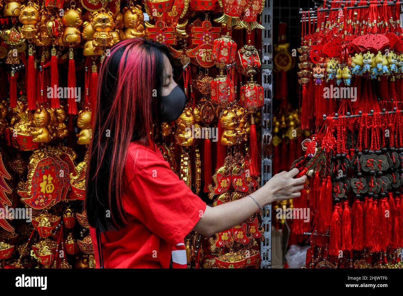 Manila, Philippines. 1st Feb, 2022. A woman wearing a protective mask as precaution against the coronavirus disease shops for lucky charms in celebration of the Lunar New Year near the Seng Guan temple in Manila's Chinatown, in the Philippines. February 1, 2022. The 2022 Lunar New Year marks the Year of the Tiger in the Chinese zodiac calendar, representing bravery, courage and strength. (Credit Image: © Basilio Sepe/ZUMA Press Wire) Stock Photo
