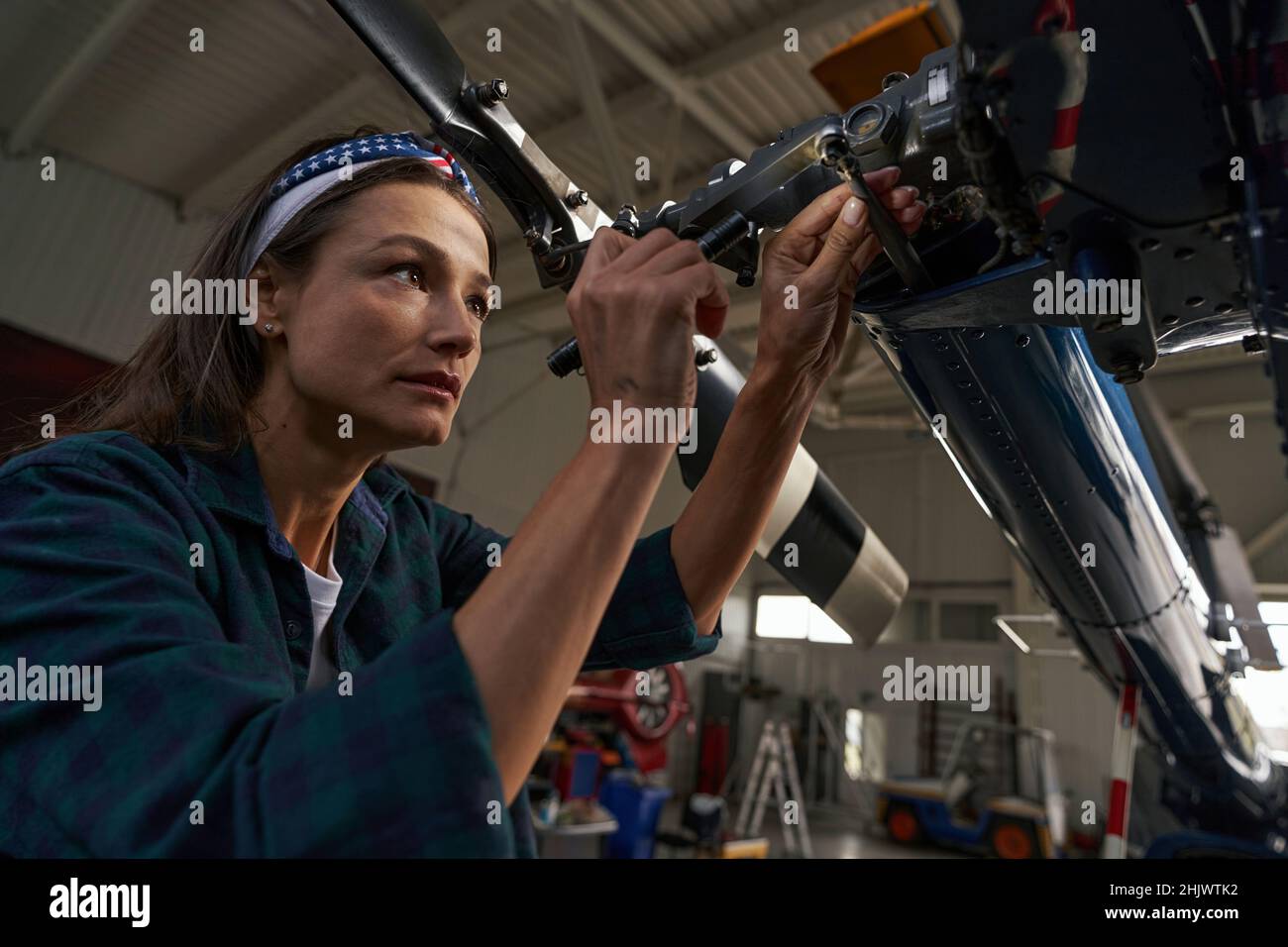 woman lead mechanic analyzing airplane parts in aviation