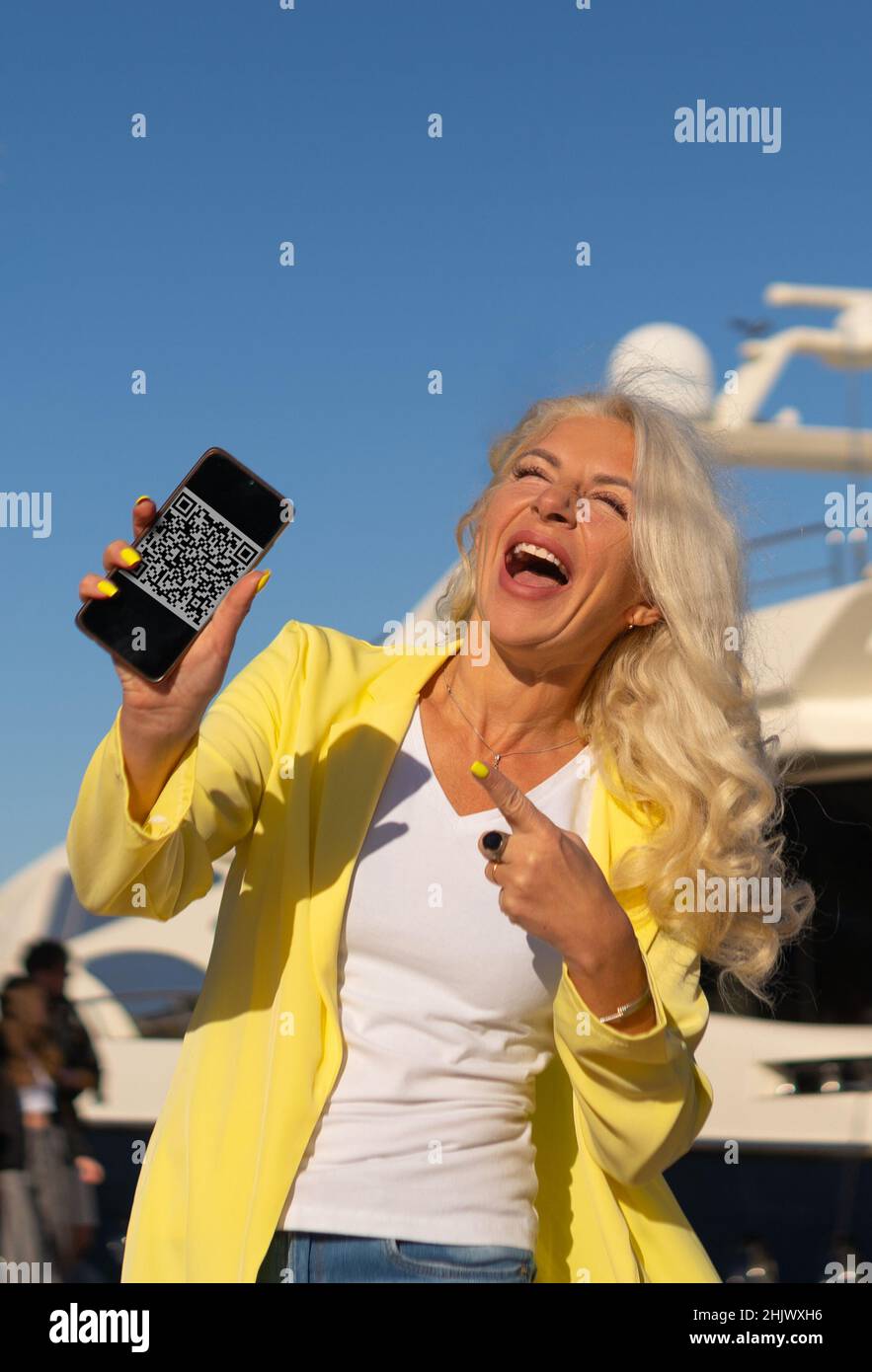 excited woman showing smartphone with qr code Stock Photo