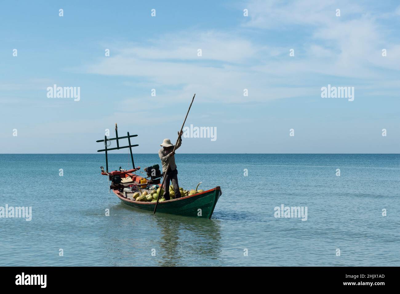 Men transporting coconuts by boat Stock Photo