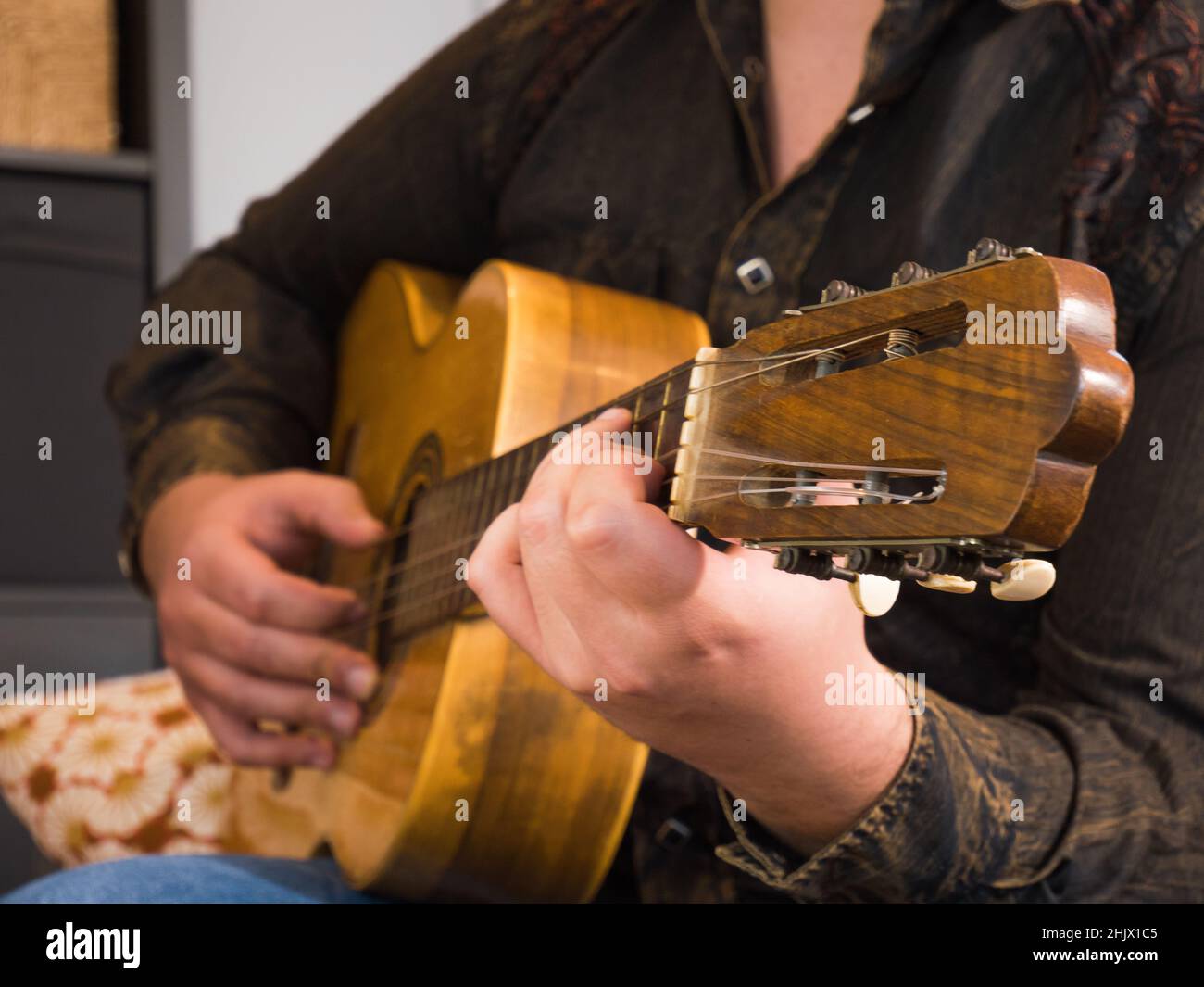 detail of a young man's hand playing the acoustic guitar Stock Photo