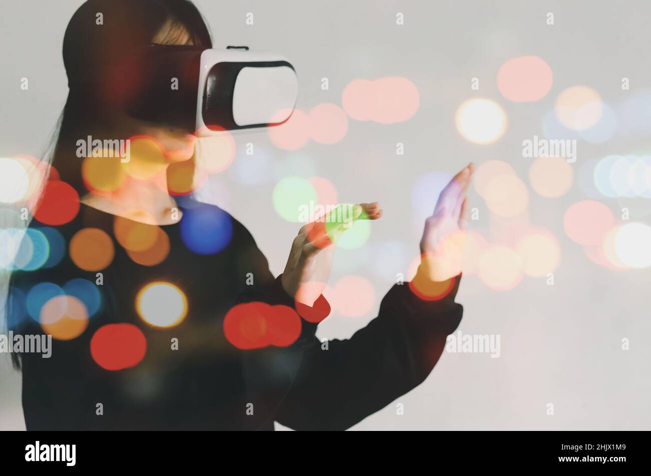 woman metaverse using virtual reality headset virtual reality device, simulation, 3D, AR, VR technology concept. Stock Photo