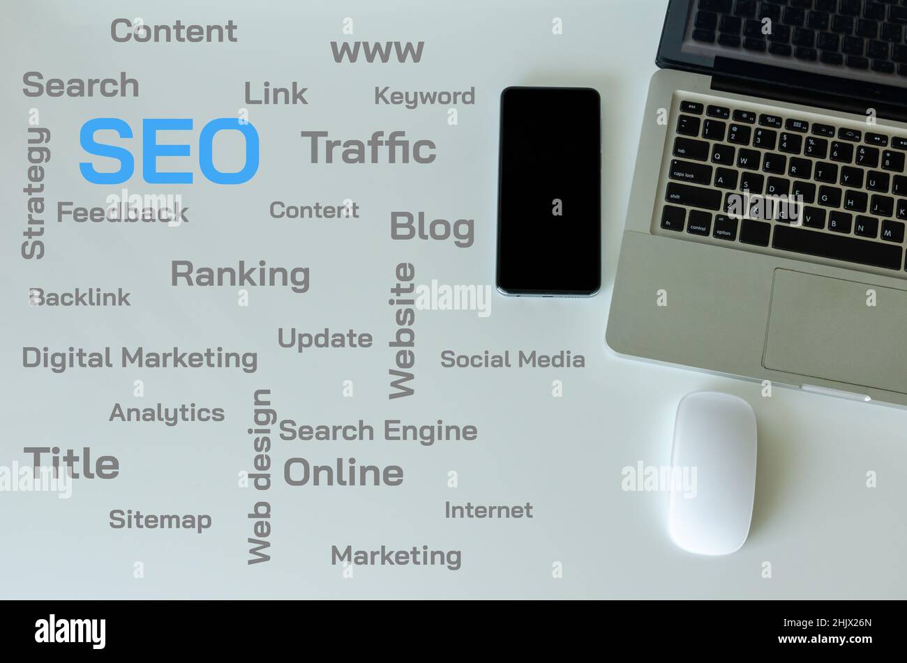 Top view laptop, smart phone and mouse are on the table. SEO and web text concepts on the table. Stock Photo
