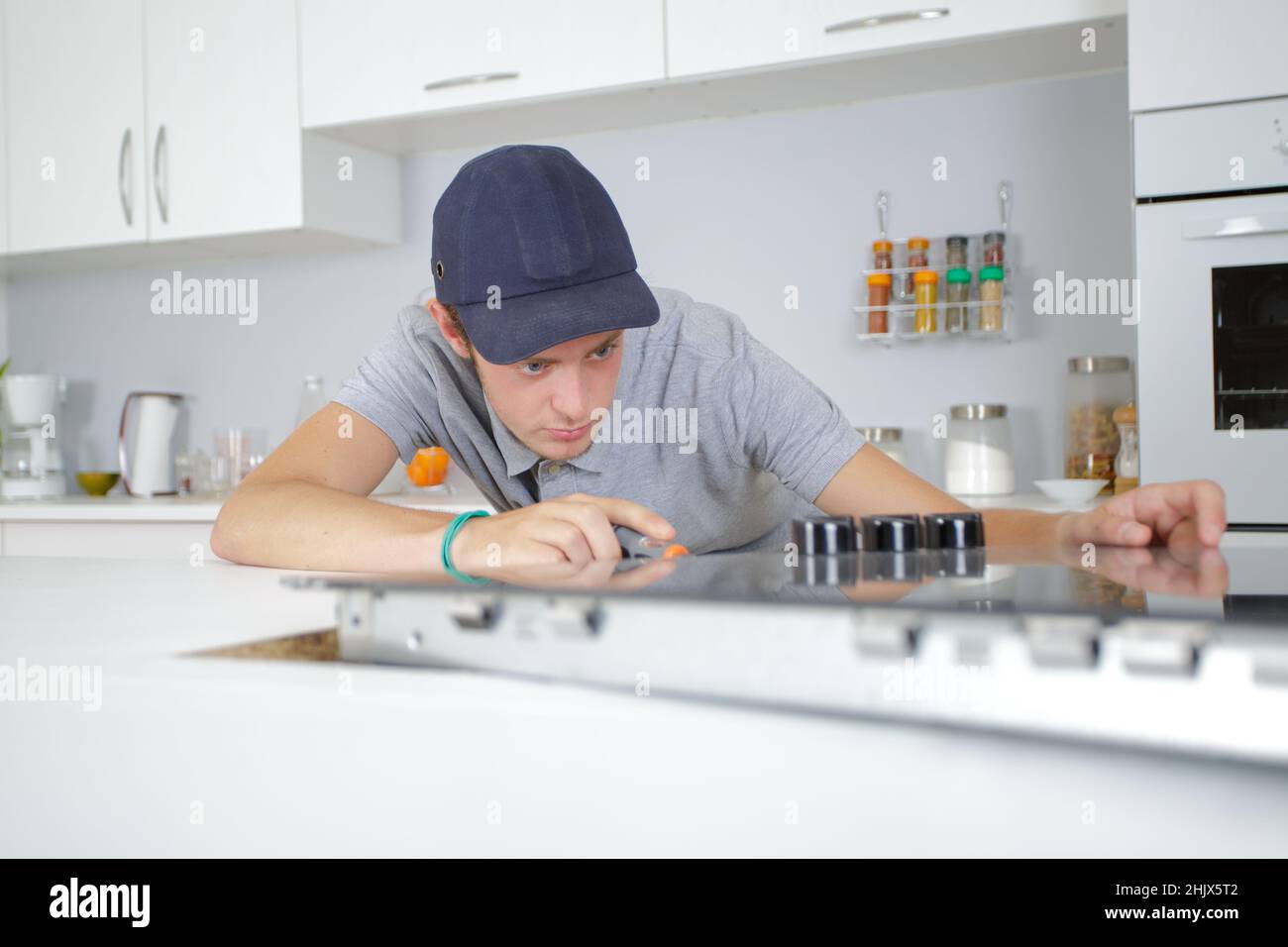 young serviceman fitting electric hob Stock Photo Alamy