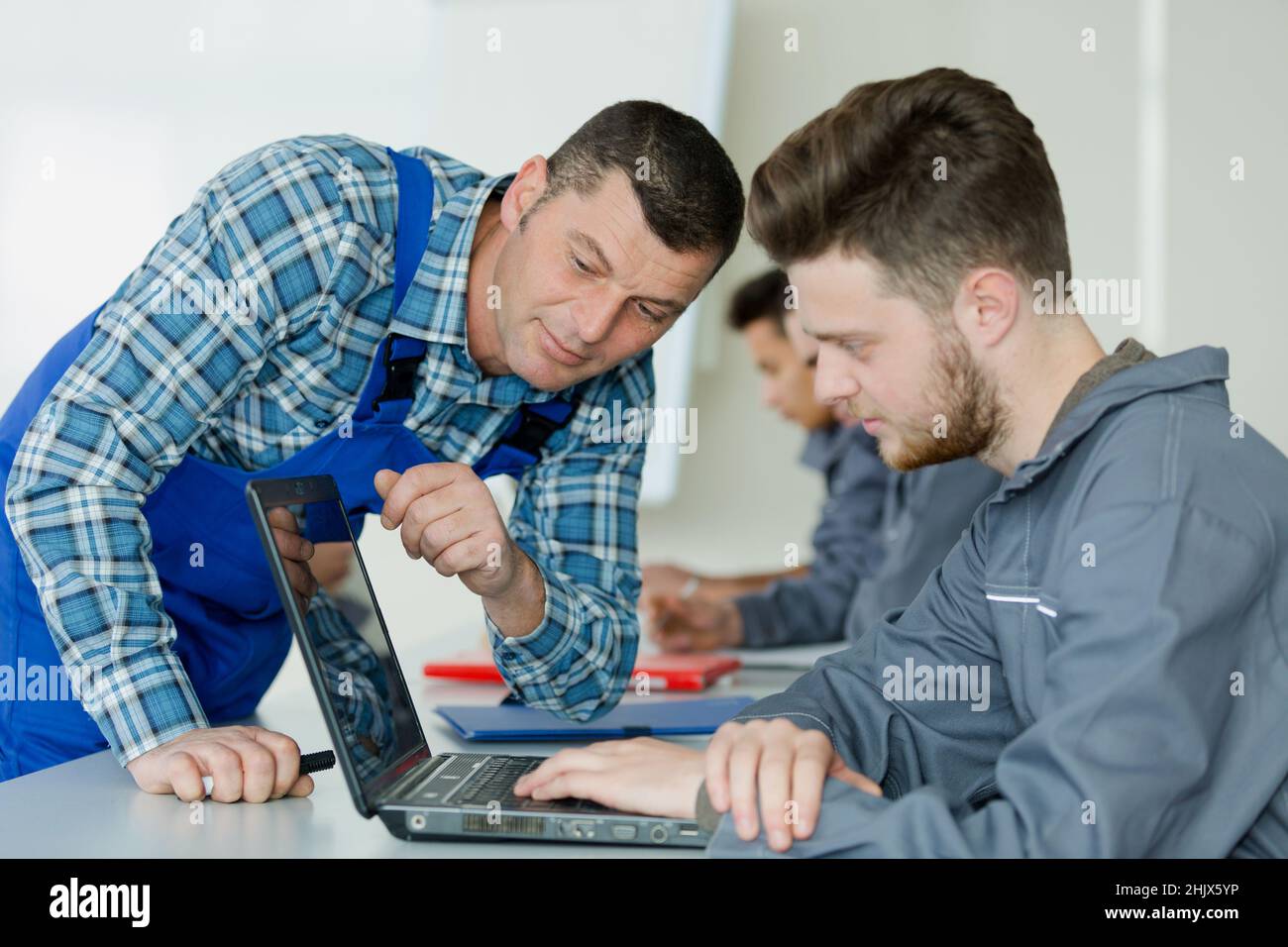 mechanical engineer working with teacher at a desk Stock Photo Alamy