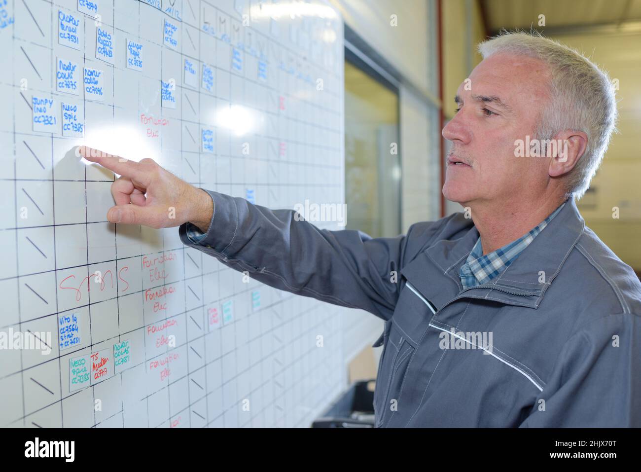 factory worker looking at timetable Stock Photo