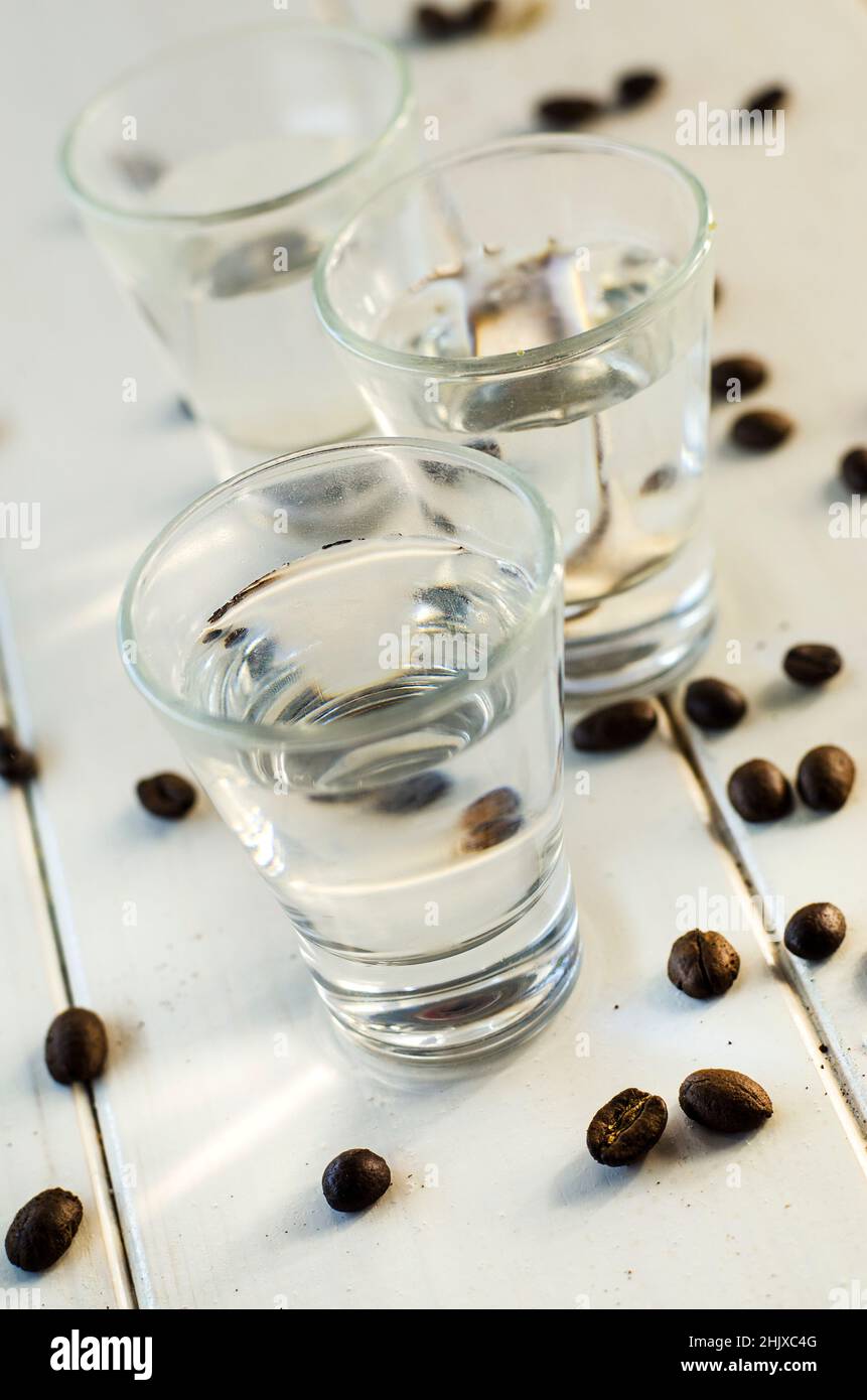 Sambuca in shot glasses and coffee beans on white background Stock ...