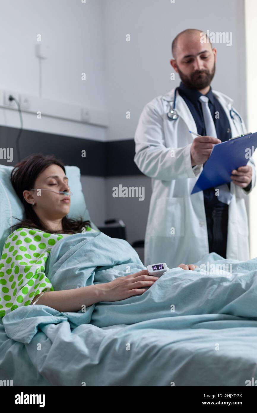 Woman with low oxygen saturation wearing nasal cannula and pulse