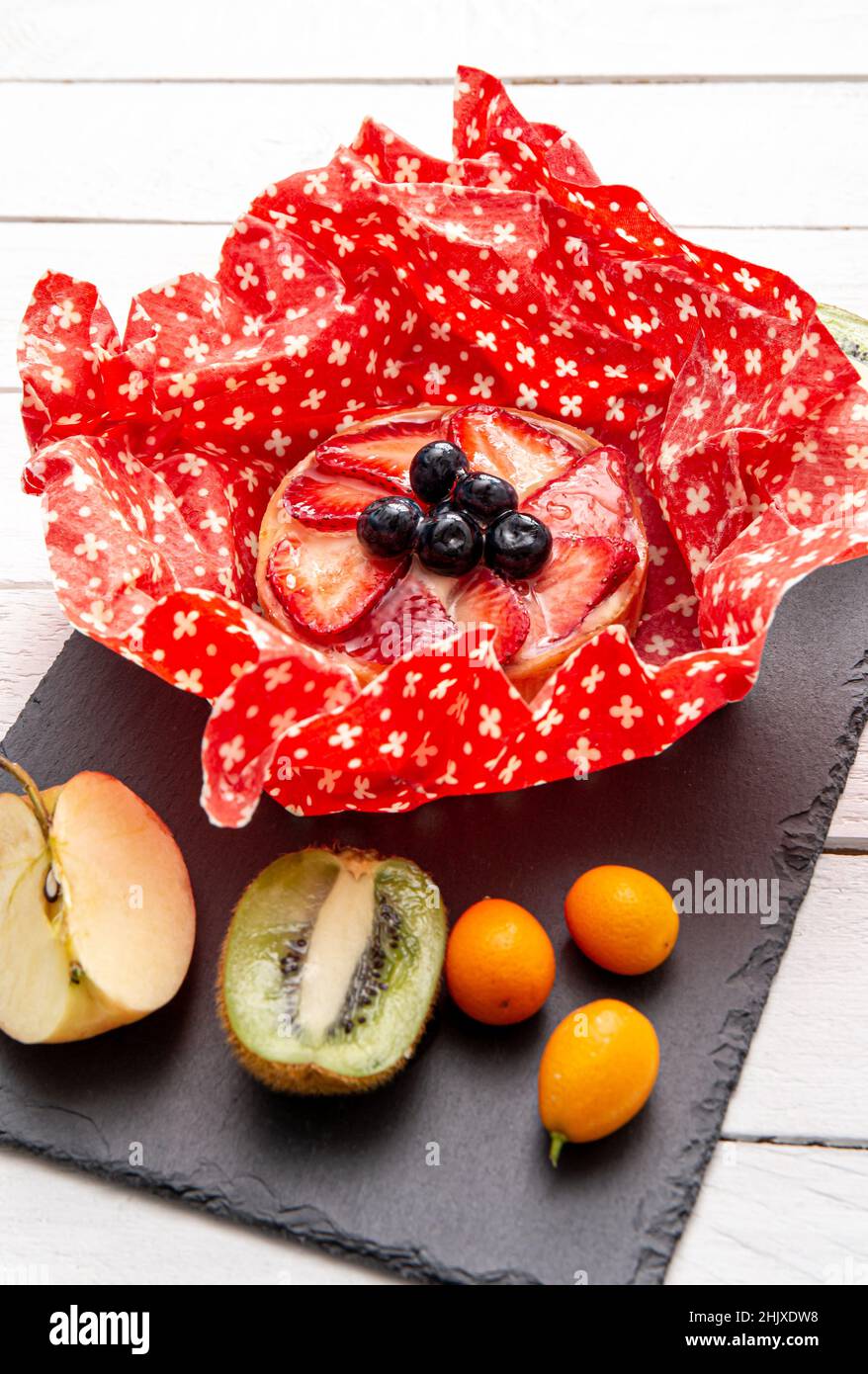 Take away cake inside homemade beeswax wraps. Wrapping food in handmade beeswax wrap cloth indoors, alternative for plastic. Stock Photo