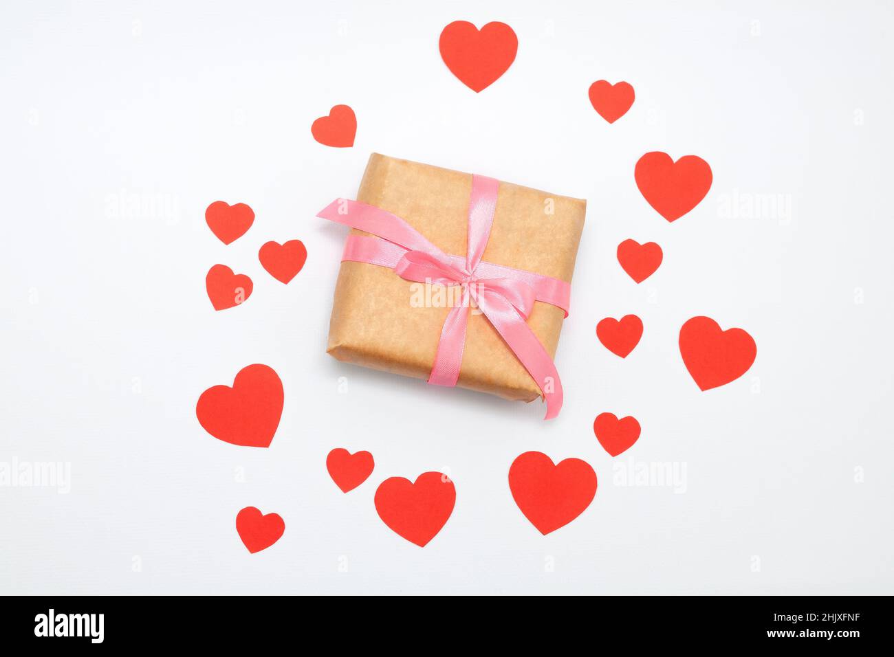 Eco gift boxes with pink ribbon and red felt hearts on white background ...