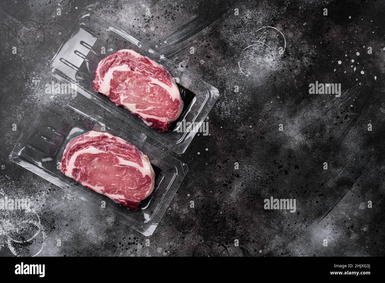 Rib eye steak pack set, on black dark stone table background, top view ...