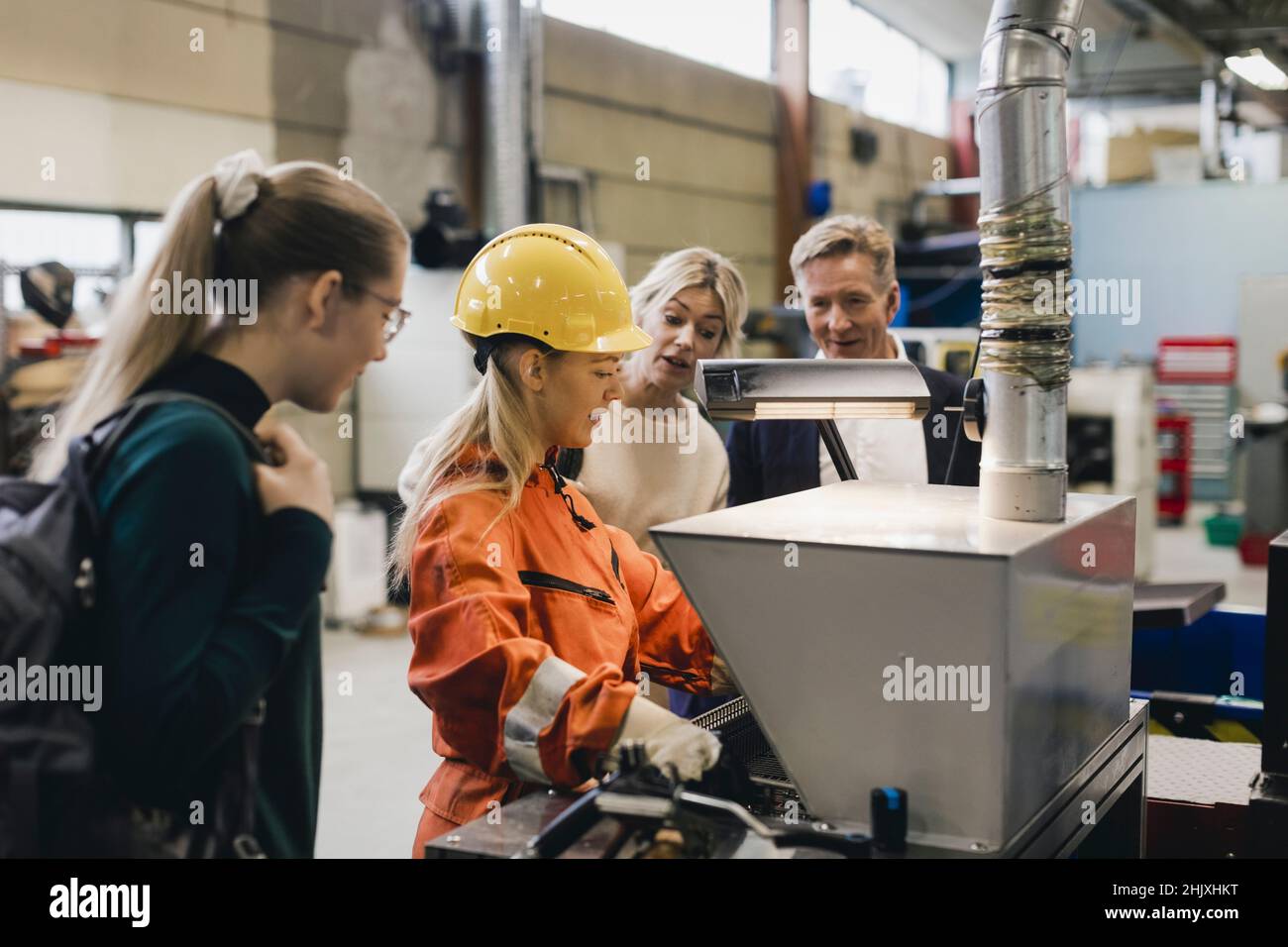 Female worker explaining businessman and his family in factory Stock Photo