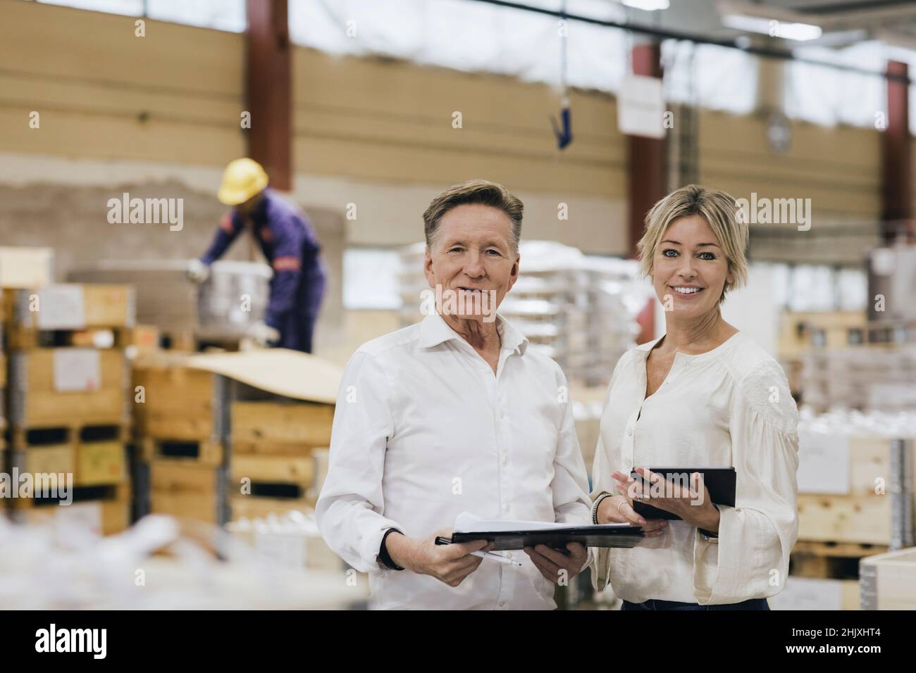 Portrait of senior businessman with daughter in factory warehouse Stock Photo