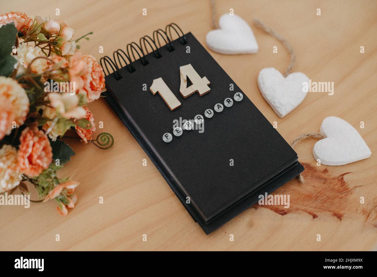 Wooden calendar on February 14 with roses and heart. Happy Valentines Day concept Stock Photo