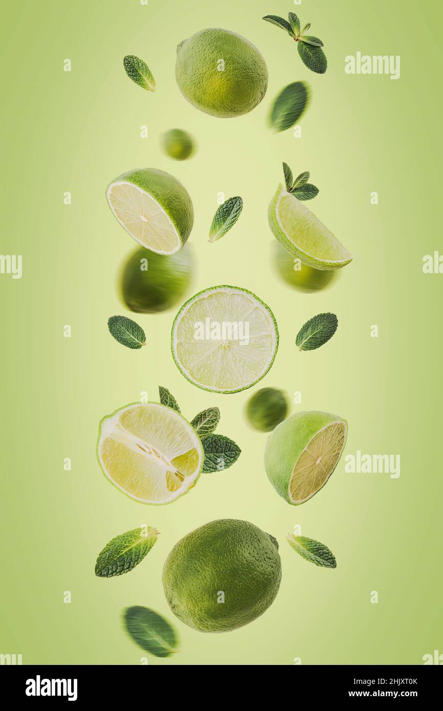 Levitating Lime slices with leafs on a green background. Selective focus. Toned image Stock Photo