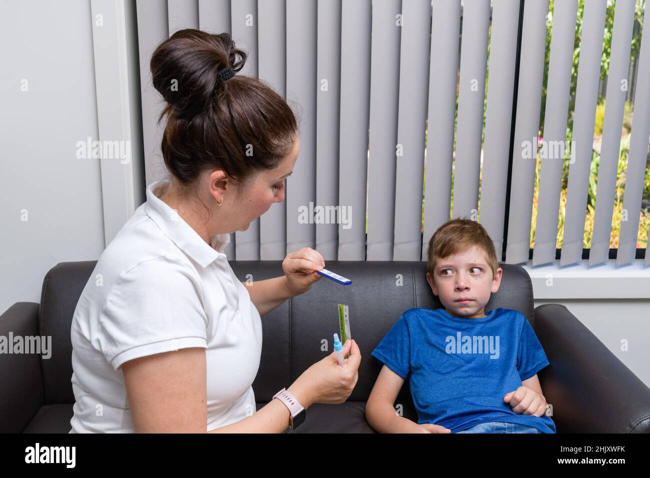 Mother going to do the COVID-19 rapid antigen test for her son at home Stock Photo