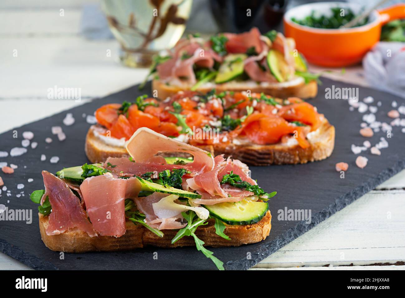 Grilled bruschetta with salmon fillet and jamon. Delicious Italian ...