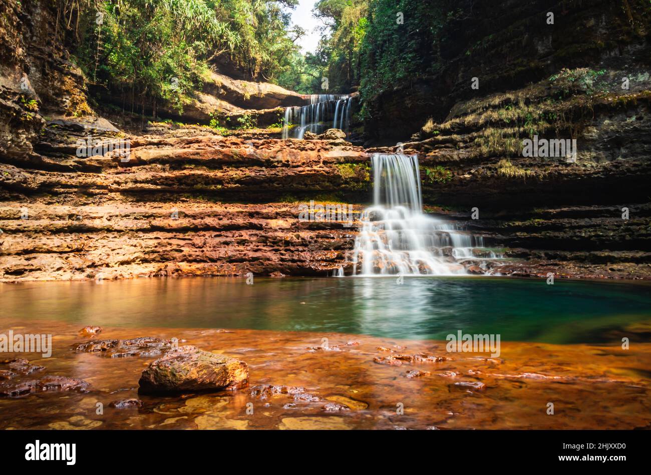 young man swimming in natural waterfall clear water at morning from top angle image is taken at wei sawdong falls cherrapunji sohra district meghalaya Stock Photo