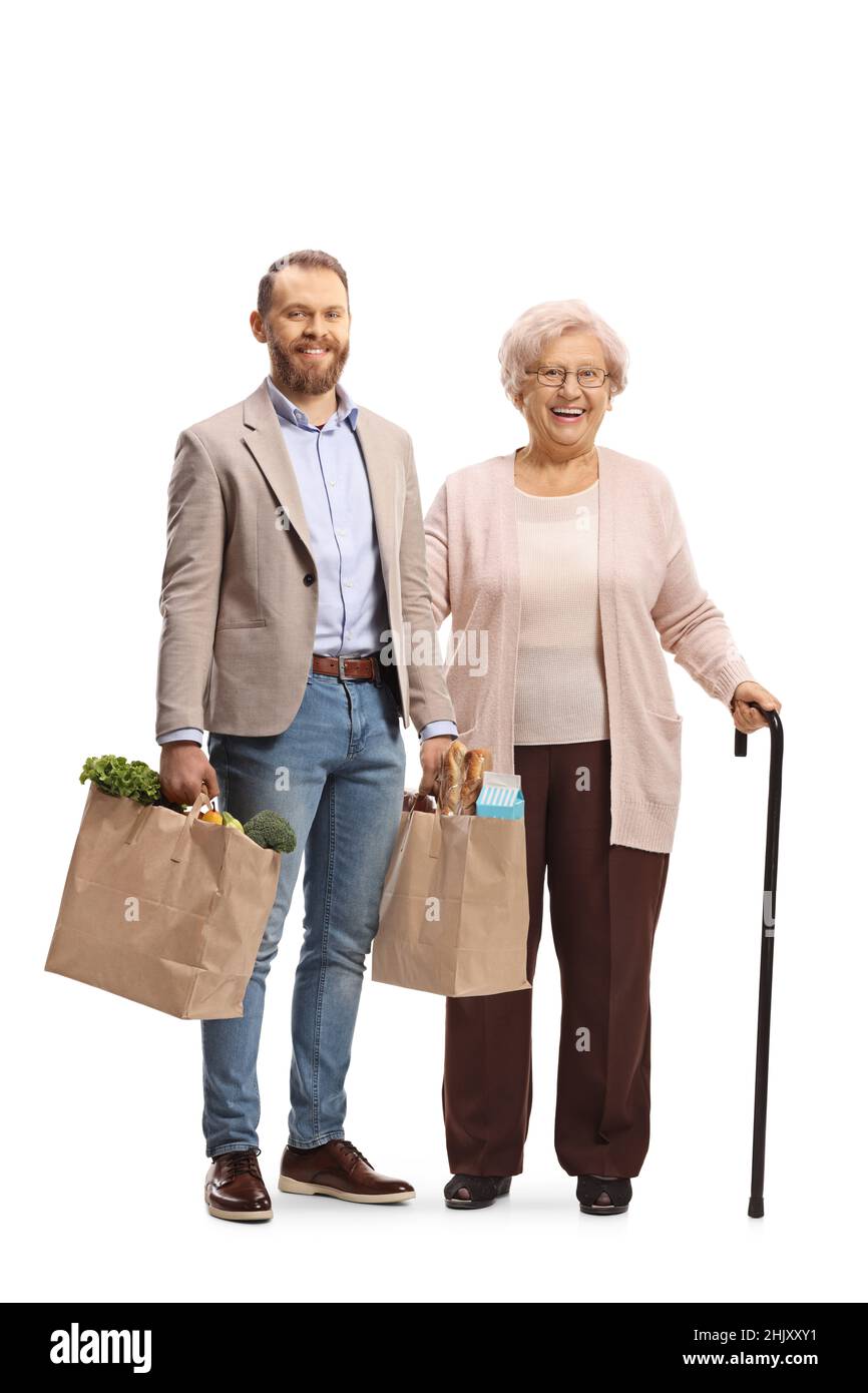 Young man helping an elderly woman and holding grocery shopping bags