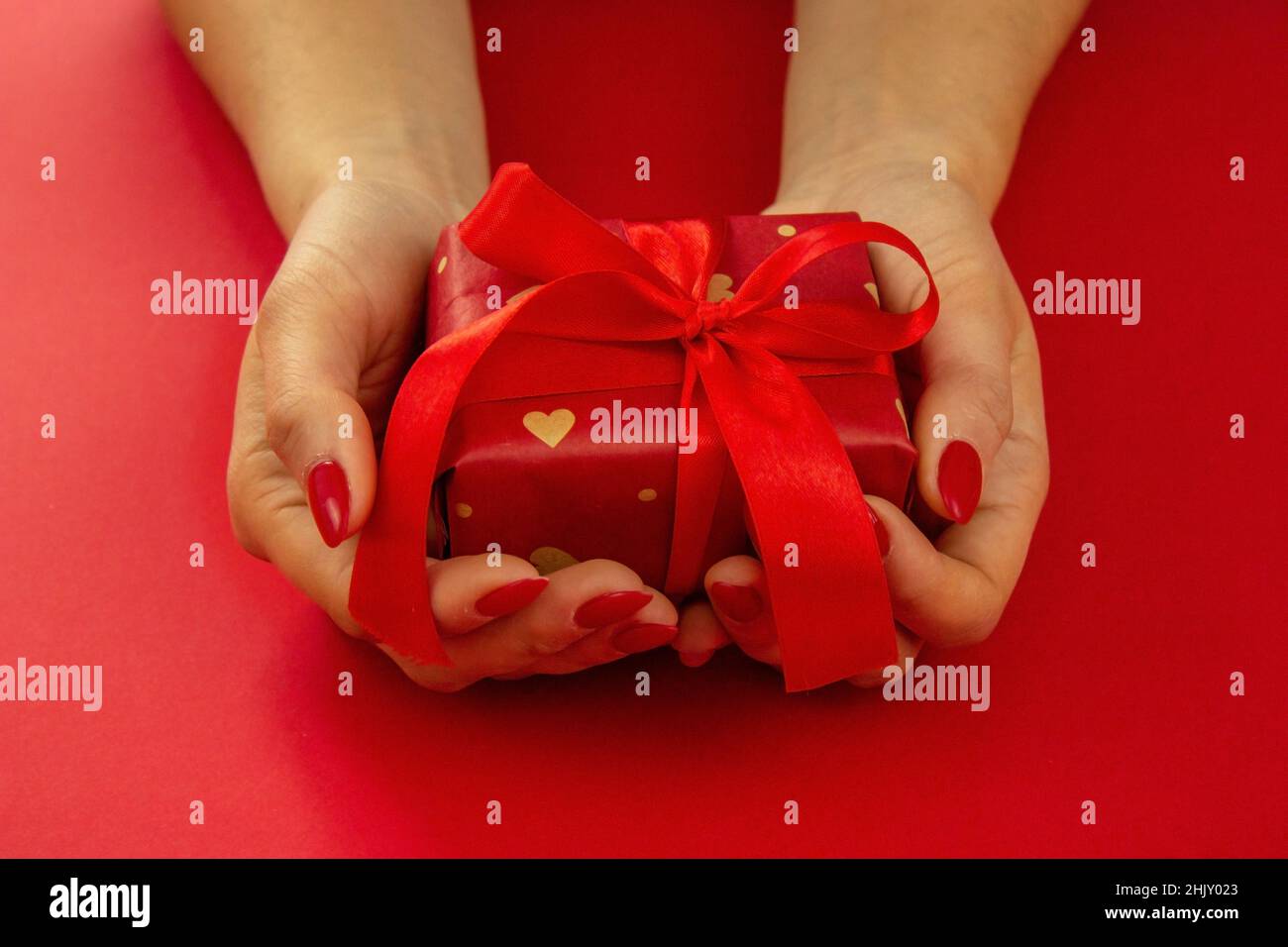 valentine. gift in hands on a red background. selective focus Stock Photo