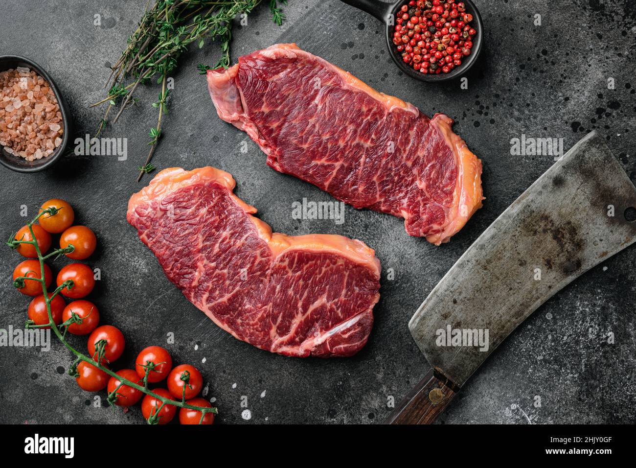 Raw striploin steak set, on black dark stone table background, top view ...