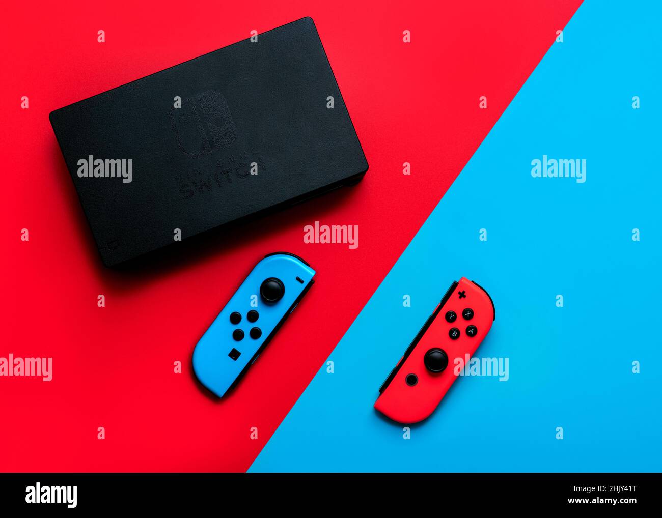Nintendo Switch video game console with Nintendo two Joy-Cons over red and blue background Stock Photo