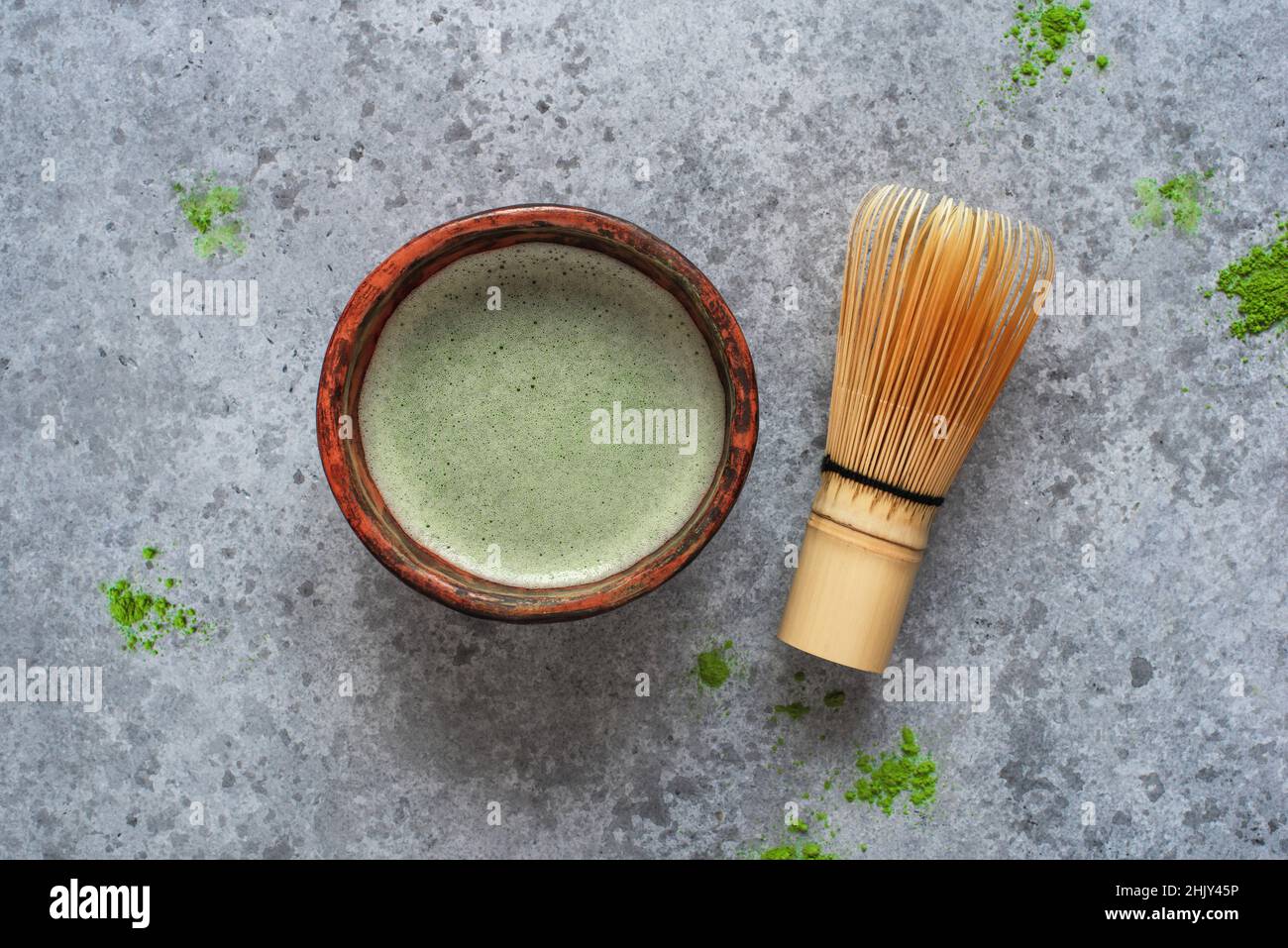 Matcha green tea in a handmade bowl with a bamboo whisk. Stock Photo